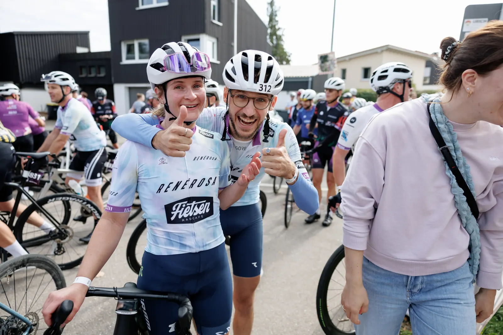 Zwei Finisher im Trikot von RenéRosa und Fietsen Radcafé zeigen lachend den Daumen hoch